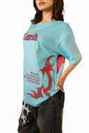 Sollzz Umbra SeaJet Oversize Tee in light blue, side view showing red "Tamsik" gothic typography and red graphic dragon print on the side, styled with dark printed jeans