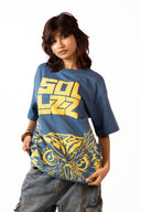 Sollzz Noctra - Silent Watcher Oversize Tee in dark navy blue featuring a female model wearing yellow block Sollzz chest typography and a yellow graphic owl artwork print, styled with gray denim cargo jeans